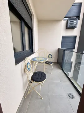 Small covered balcony with patio furniture. - image 7