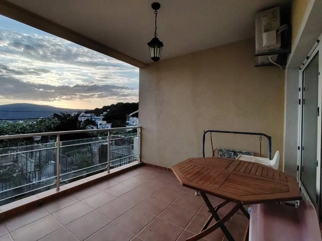 Natkriveni balkon sa garniturom za sedenje i pogledom na prirodu i okolinu.