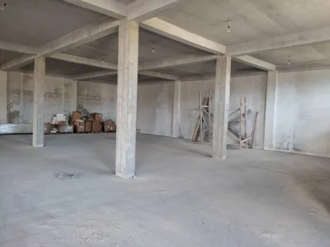 Spacious unfinished interior space in shell stage with concrete pillars. - image 2