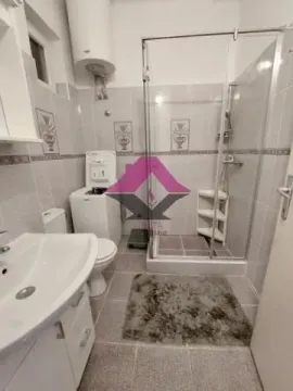 Bathroom with a shower cabin, washbasin, washing machine, and toilet. - image 13