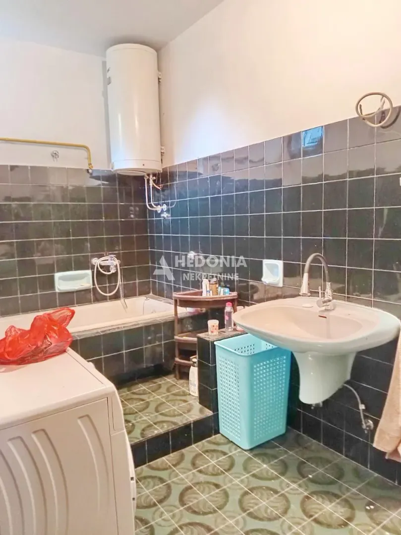 Bathroom equipped with a bathtub, sink, and water heater.