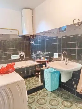 Bathroom equipped with a bathtub, sink, and water heater. - image 4