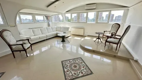 Spacious living room with seating furniture and large windows with a city view. - image 2