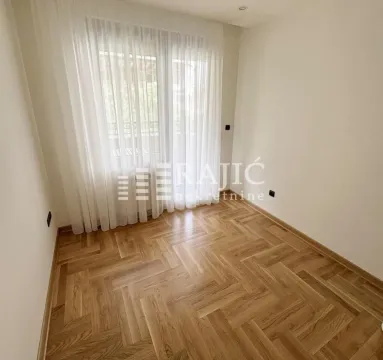 Prazna soba sa parketom i prozorom sa belim zavesama. - image 7
