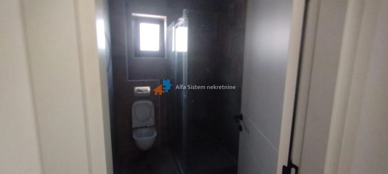 Pogled na kupatilo sa tuš kabinom i ugradnom wc šoljom.