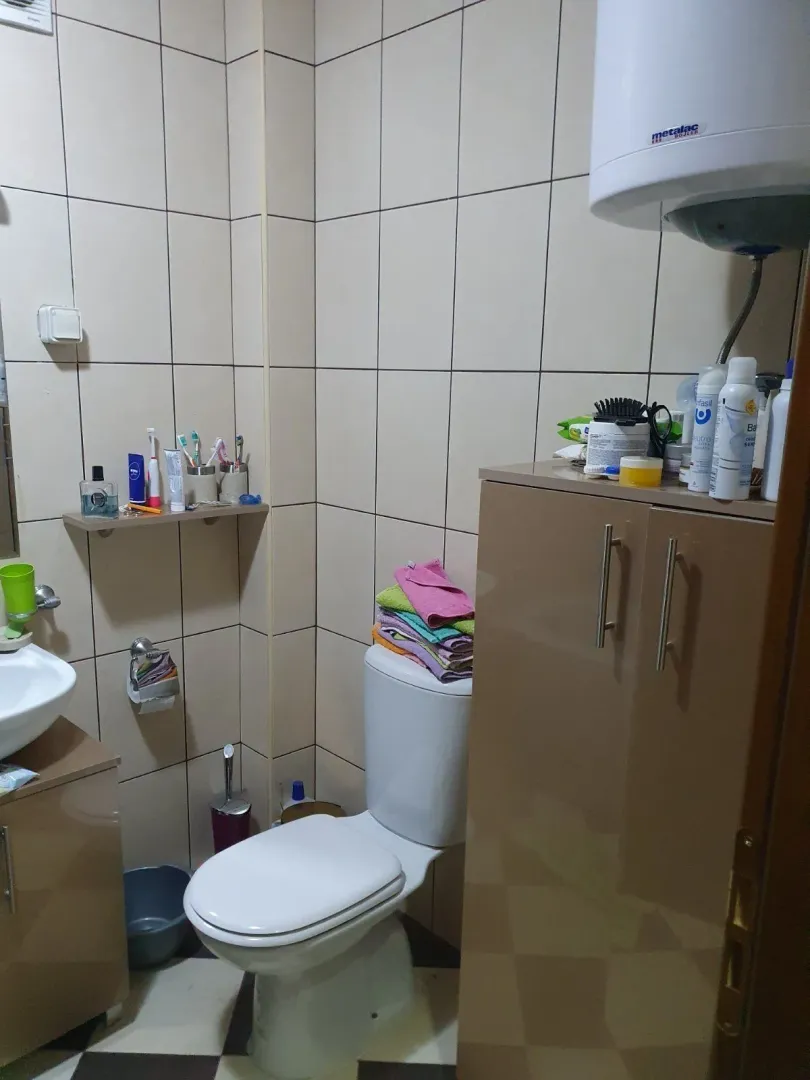 Malo kupatilo sa toaletom, ormarićem i bojlerom.