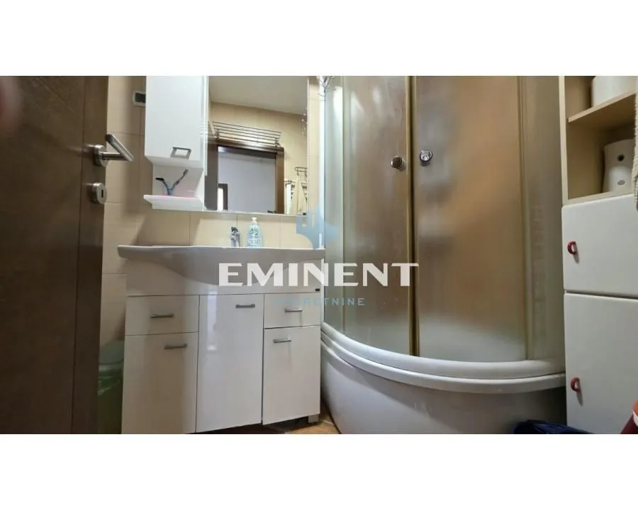 Small bathroom with a washbasin, mirror, and shower cabin.