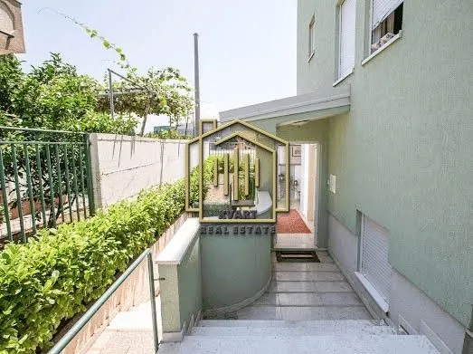 Entrance to the house with stairs and a landscaped yard.