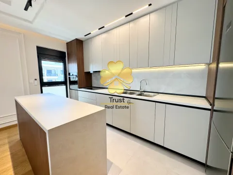 Modern kitchen with white cabinetry, an island, and built-in lighting. - image 6