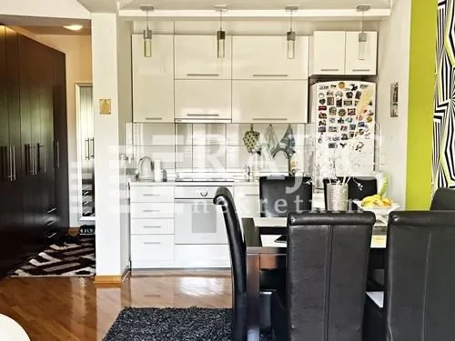 Modern kitchen with white units and a dining table.