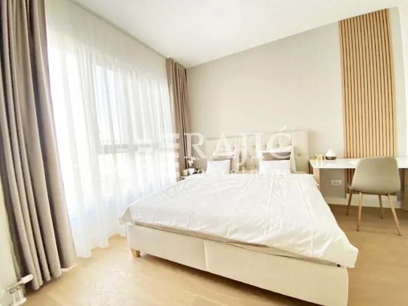 Bright bedroom with a double bed and a desk.