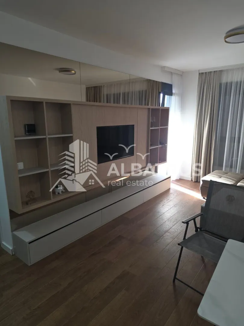 Living room with a large wooden TV unit and built-in shelving.