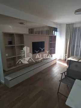Living room with a large wooden TV unit and built-in shelving. - image 14