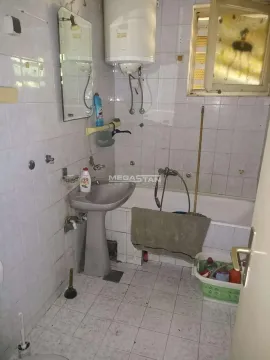 Starije opremljeno kupatilo sa umivaonikom, kadom i pločicama na zidovima. - image 5