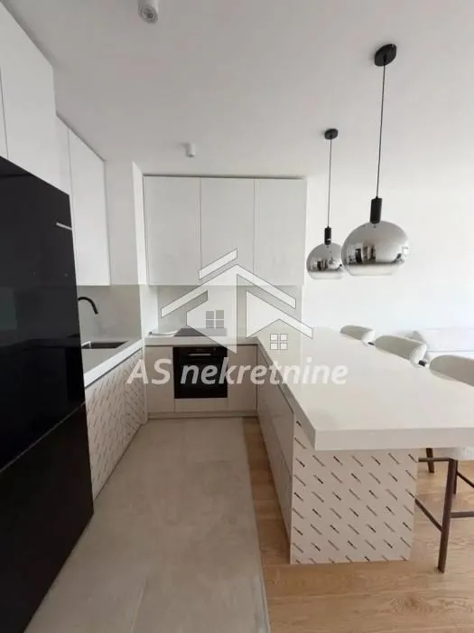 Modern kitchen with white cabinetry and a breakfast bar.