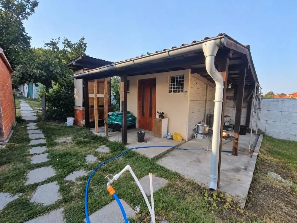 Eksterijer prizemnog objekta sa nadstrešnicom i dvorištem.