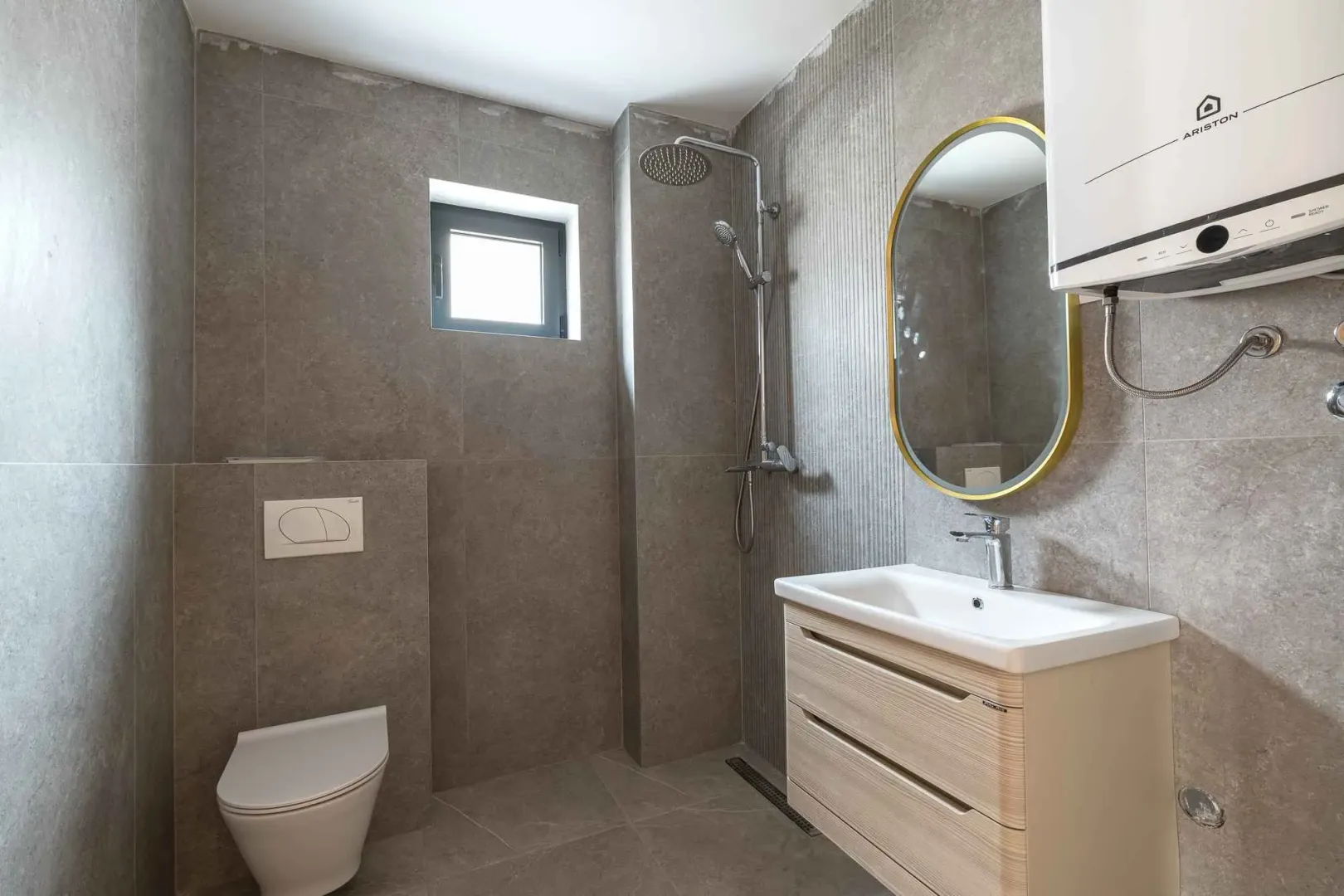 Moderne kupatilo sa tuš kabinom, umivaonikom i ugradnom wc šoljom.