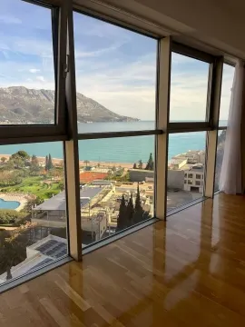 View of the sea and surroundings through a large window from a room with wooden flooring. - image 26