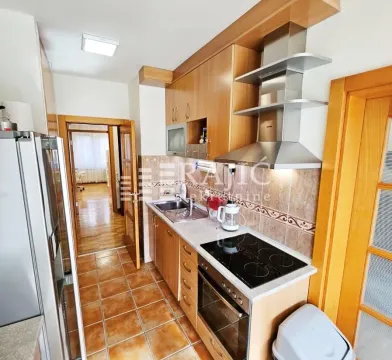 Small kitchen with wooden cabinetry and built-in appliances. - image 5