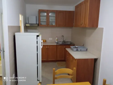 A simple kitchen with wooden cabinets and white appliances. - image 4