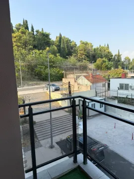 View from the balcony overlooking the surrounding greenery and street. - image 2