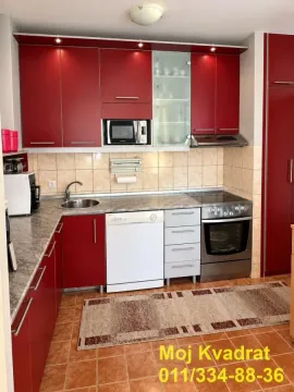 Kitchen with red cabinets, a sink, and built-in appliances. - image 7