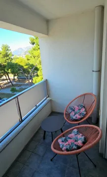 Natkriveni balkon sa dvije fotelje i stočićem, i pogledom na zelenilo. - image 5
