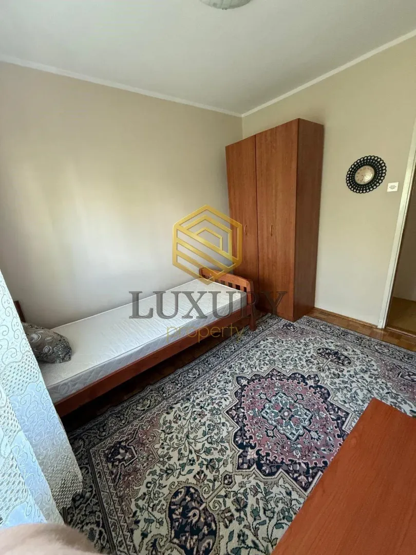 Smaller bedroom with a bed, wardrobe, and carpet.