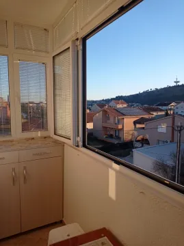 Glazed balcony with storage cabinets and a view of the neighborhood. - image 9