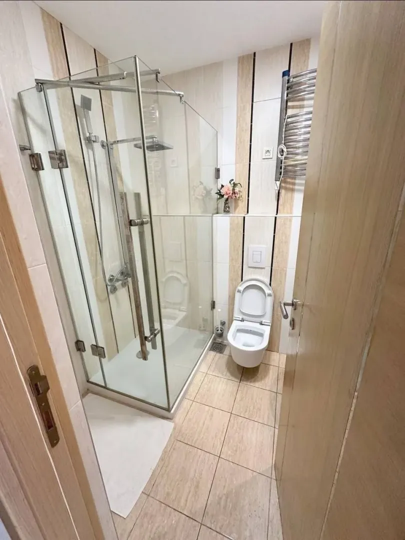 Manje kupatilo sa tuš kabinom i ugradnom wc šoljom.