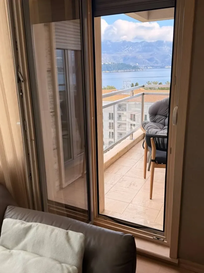 Pogled sa terase na more i planine kroz balkonska vrata.