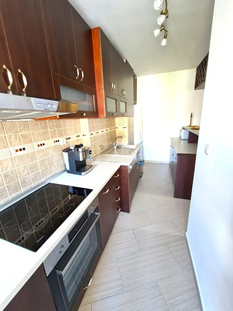 Kitchen with dark wooden cabinetry and built-in appliances.