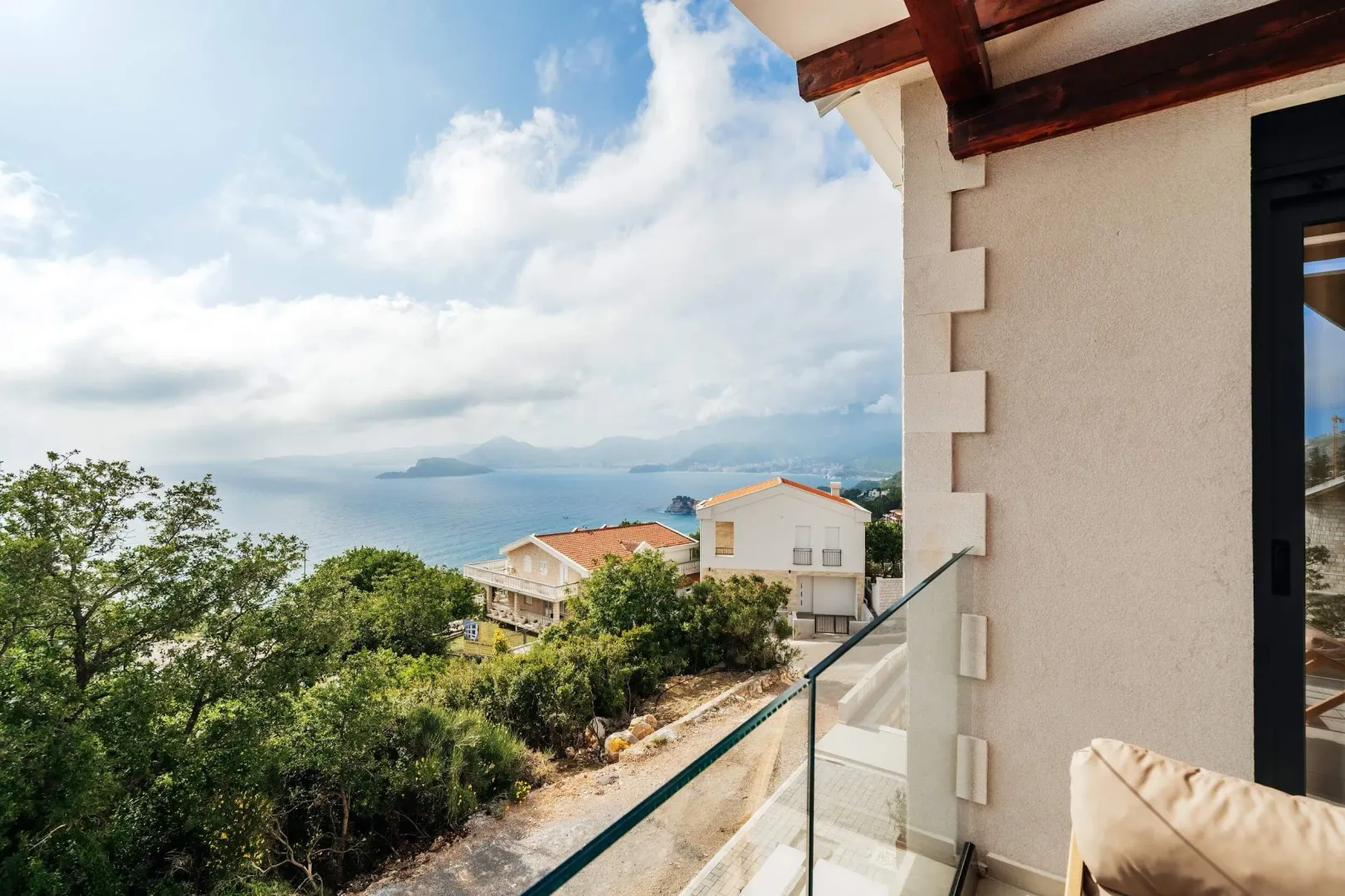 Sea view from the terrace with a glass railing.