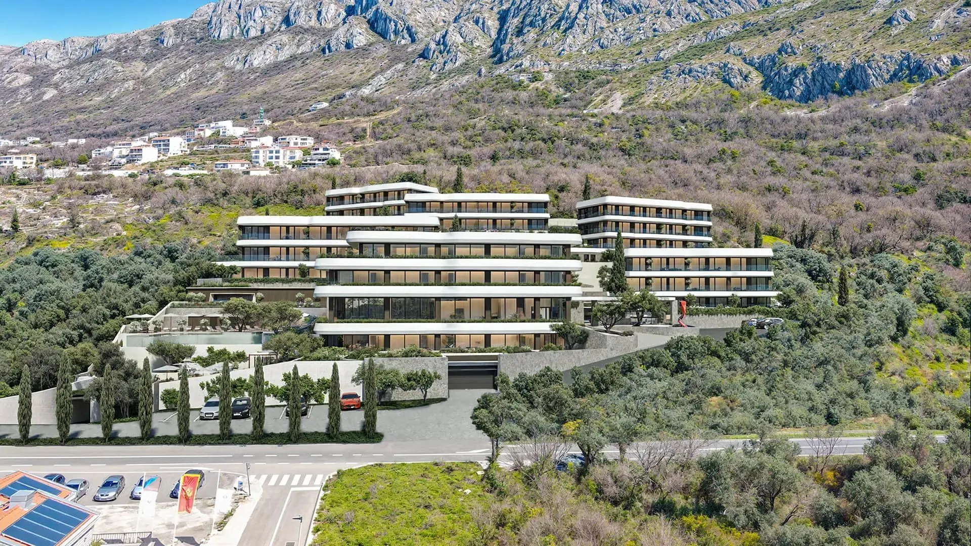 Pogled iz vazduha na moderan stambeni kompleks smješten u prirodi blizu planine.
