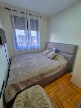 Spavaća soba sa bračnim krevetom i prozorom sa zavesama. - image 5