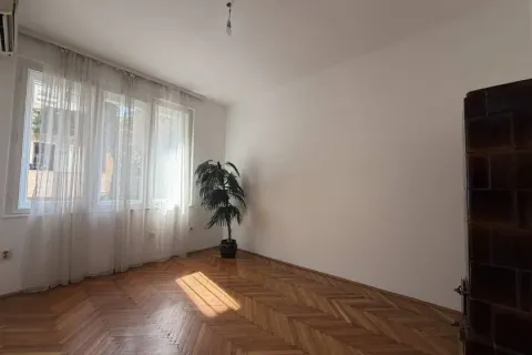 Empty room with parquet flooring and a large window with curtains. - image 11