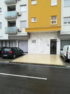Glavni ulaz u stambenu zgradu sa popločanim prilazom i parkiranim automobilima ispred. - image 6