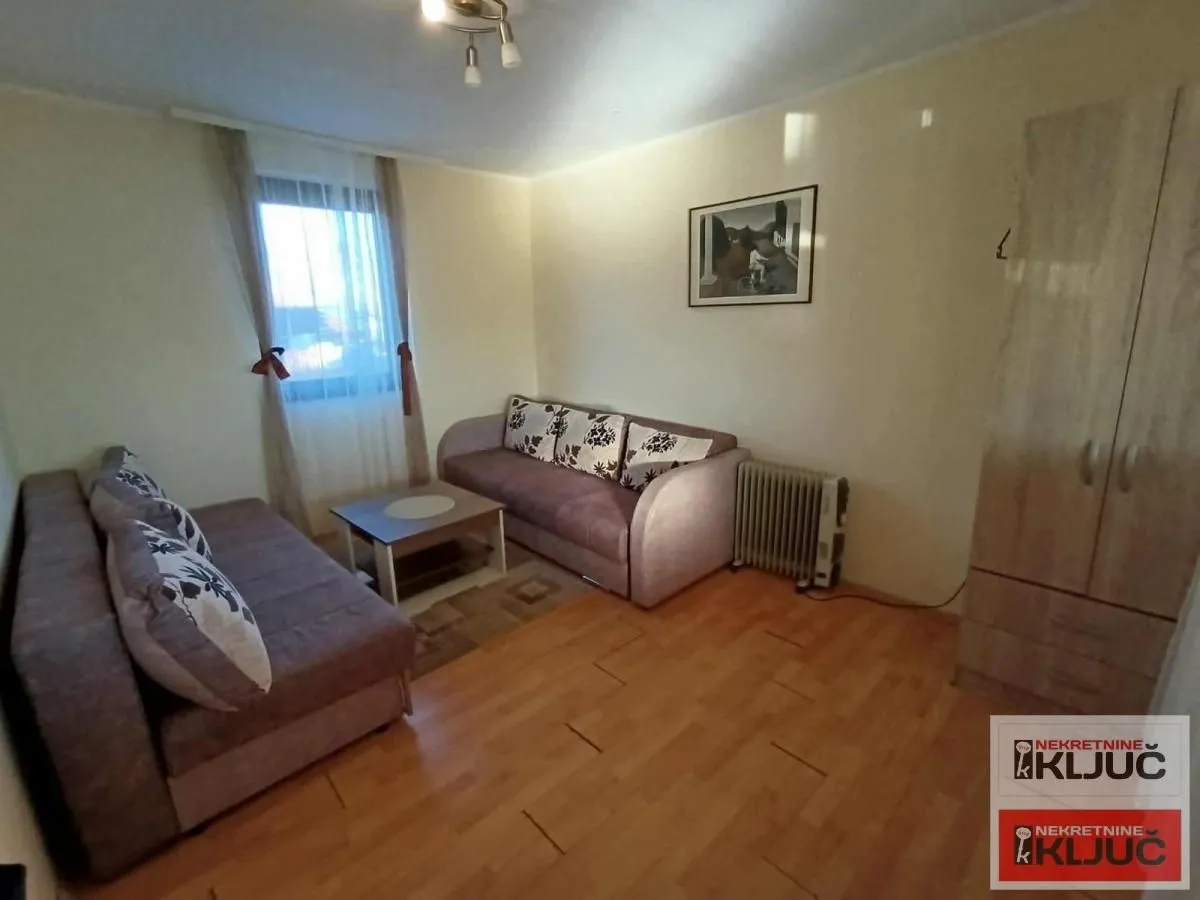 Living room with sofa set, coffee table, and a window.