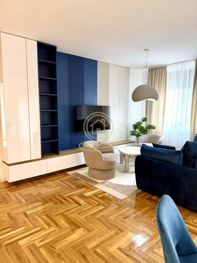 Living room with a sofa set, television, and hardwood flooring.