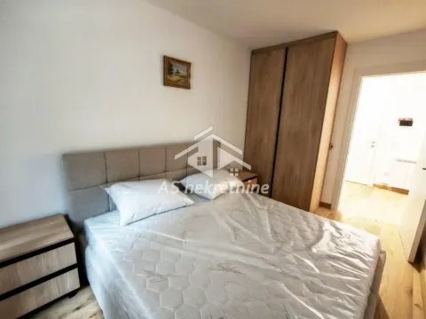 Furnished bedroom with a double bed, wardrobe, and bedside tables. - image 10