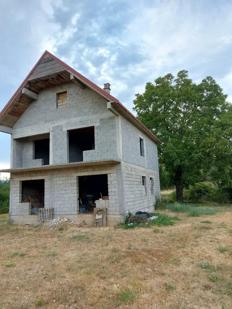 Nedovršena kuća u izgradnji sa dvorištem.