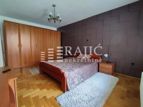 Furnished bedroom with a double bed, large wooden wardrobe, and parquet flooring. - image 3
