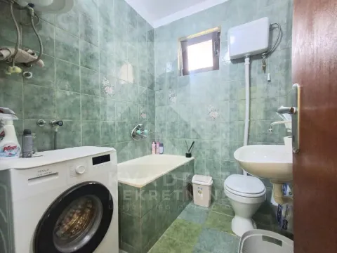 Kupatilo obloženo zelenim pločicama sa kadom, umivaonikom, WC šoljom i veš mašinom. - image 8