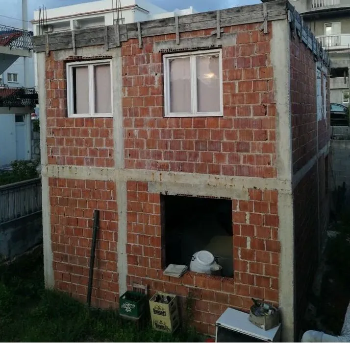An unfinished brick house under construction.