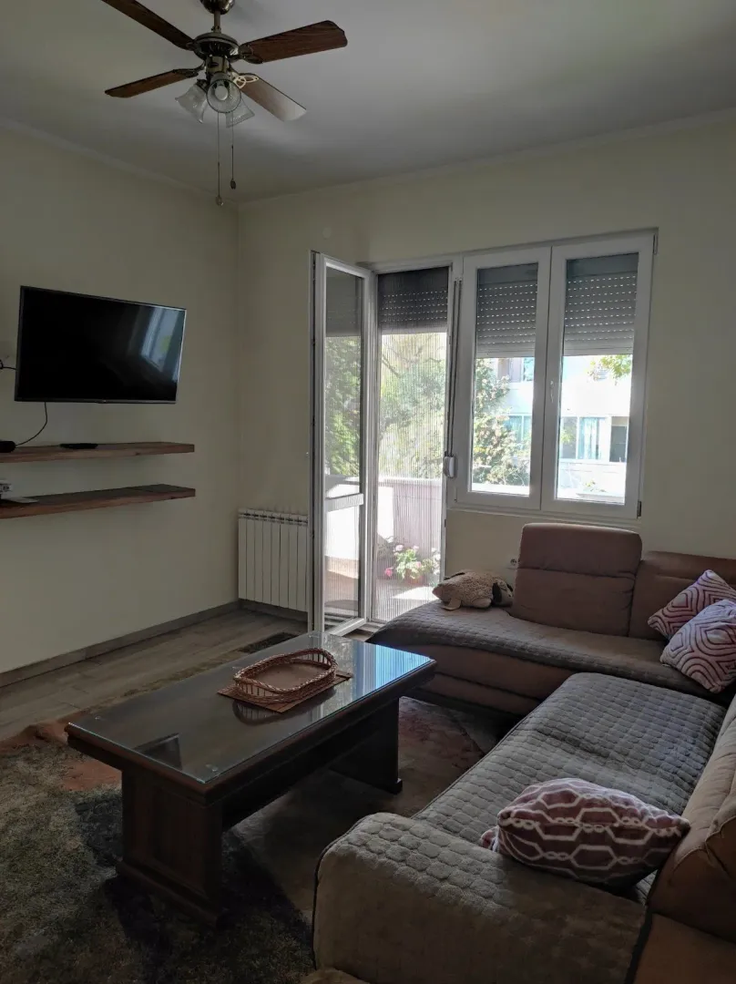 Bright living room with a corner sofa and balcony access.