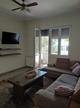 Bright living room with a corner sofa and balcony access. - image 9