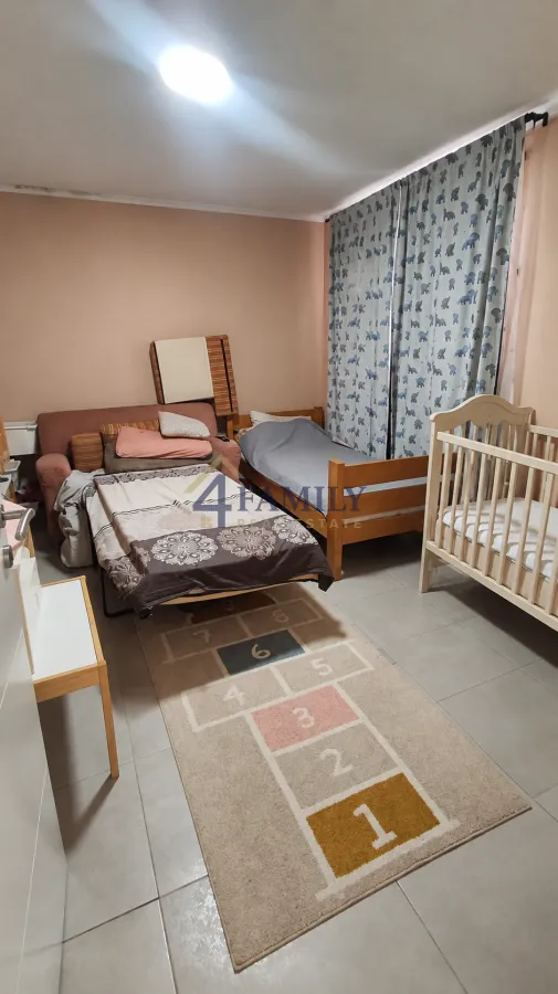 Children's bedroom with a bed, crib, and couch.