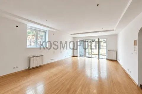 Empty spacious room with wooden flooring, radiators, and terrace access. - image 2