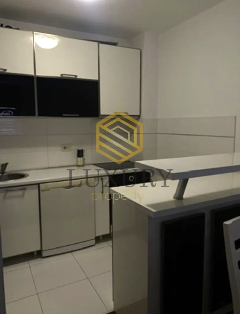 Modern kitchen with white cabinets and a breakfast bar.