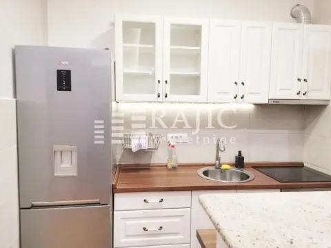 Small kitchen with white cabinets, refrigerator, and wooden countertops. - image 2